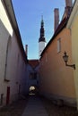 Medieval Narrow Street in Tallinn with a lantern on the wall and a church in front, Estonia Royalty Free Stock Photo